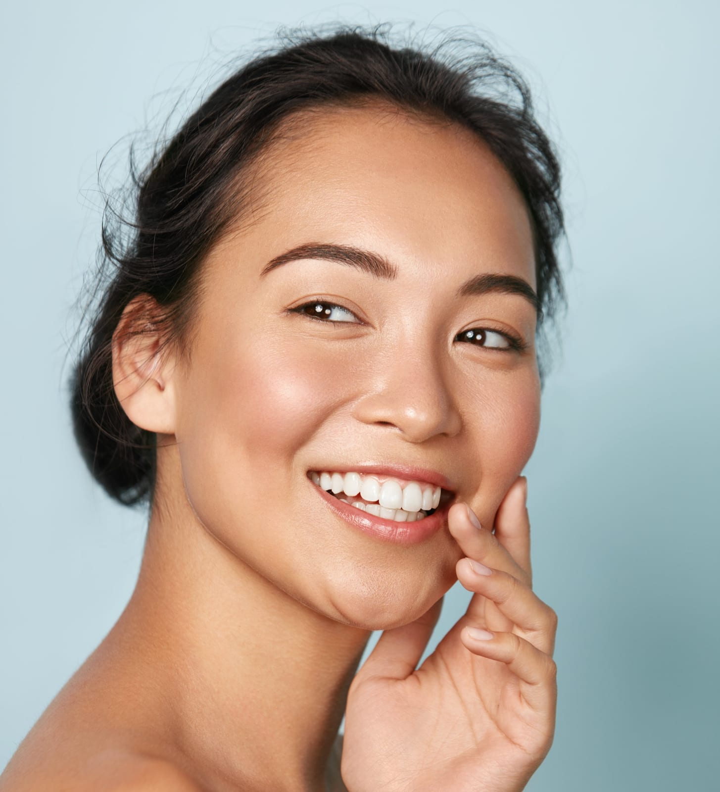 Laser resurfacing | A woman posing with a smile and hand on face