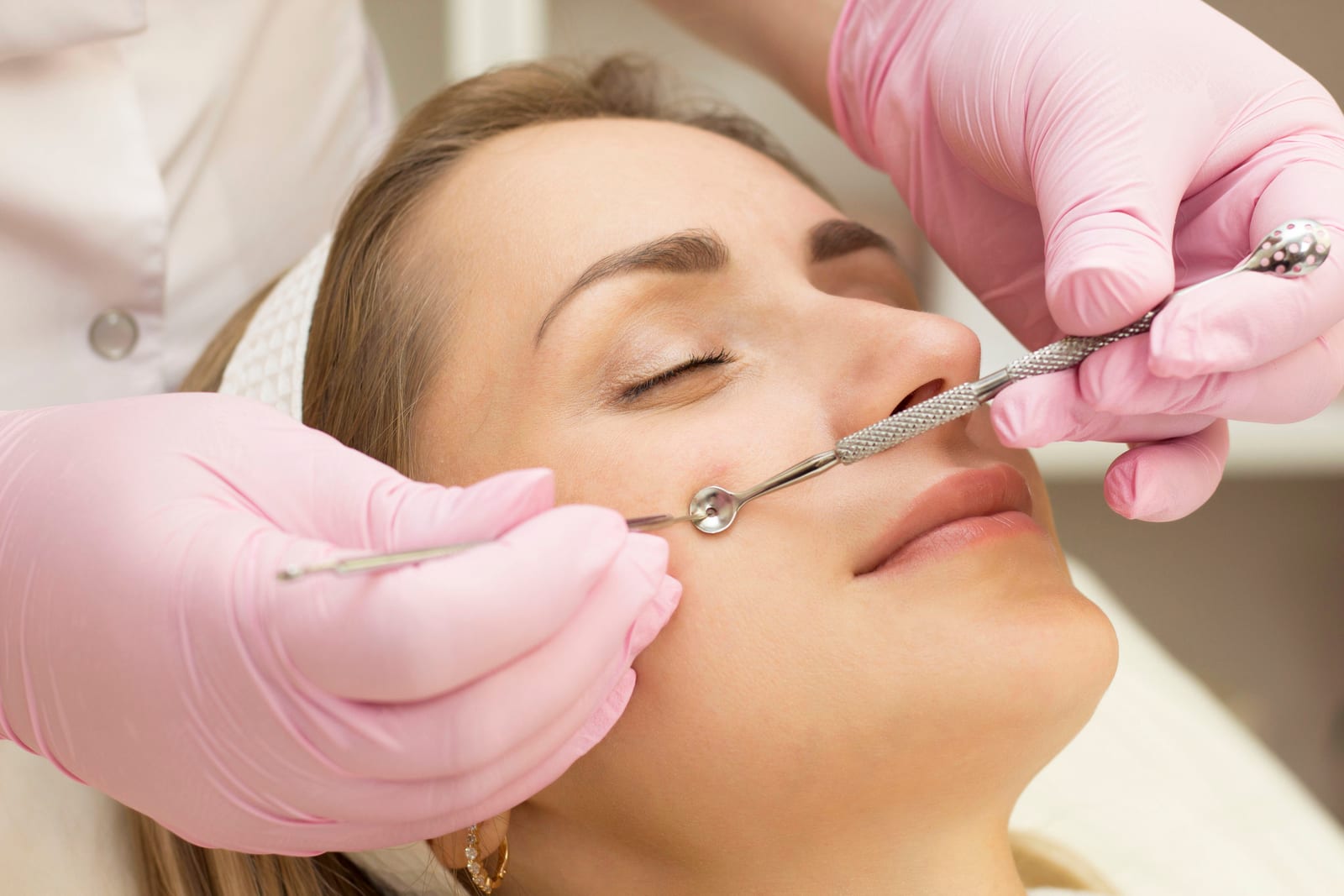 Facial treatment | An aesthetician performing manual facial cleaning on a female client.