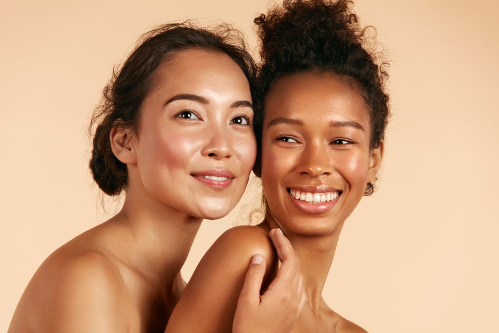 HydraFacial | Two women posing for a camera and smiling.