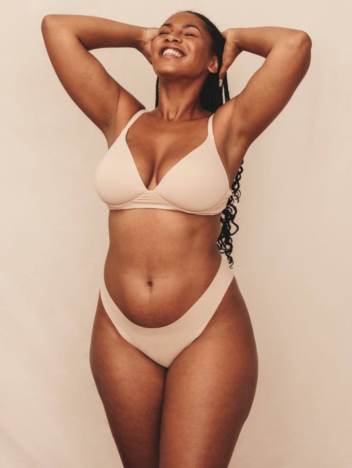 Exilis | A portrait photo of a happy woman posing in a bikini