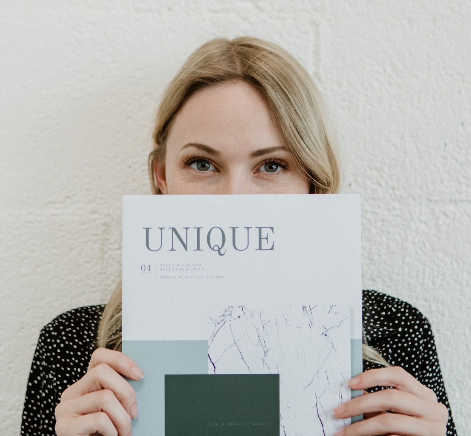ClearLift | A woman holding up a magazine that says "unique"